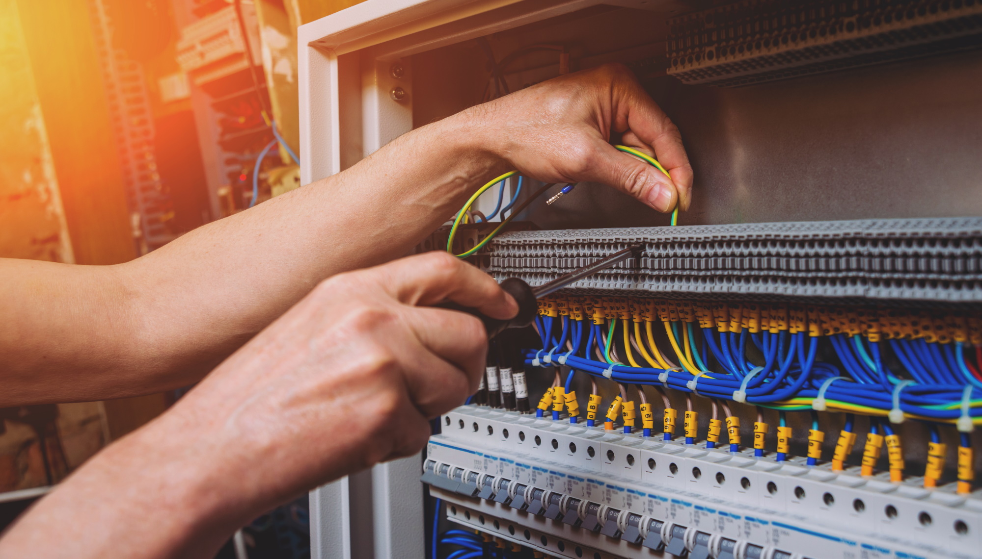 PEAG Personal überlässt Fachkräfte: Das Bild zeigt die Hände einer Fachkraft, die an einem elektrischen Schaltkasten arbeitet.